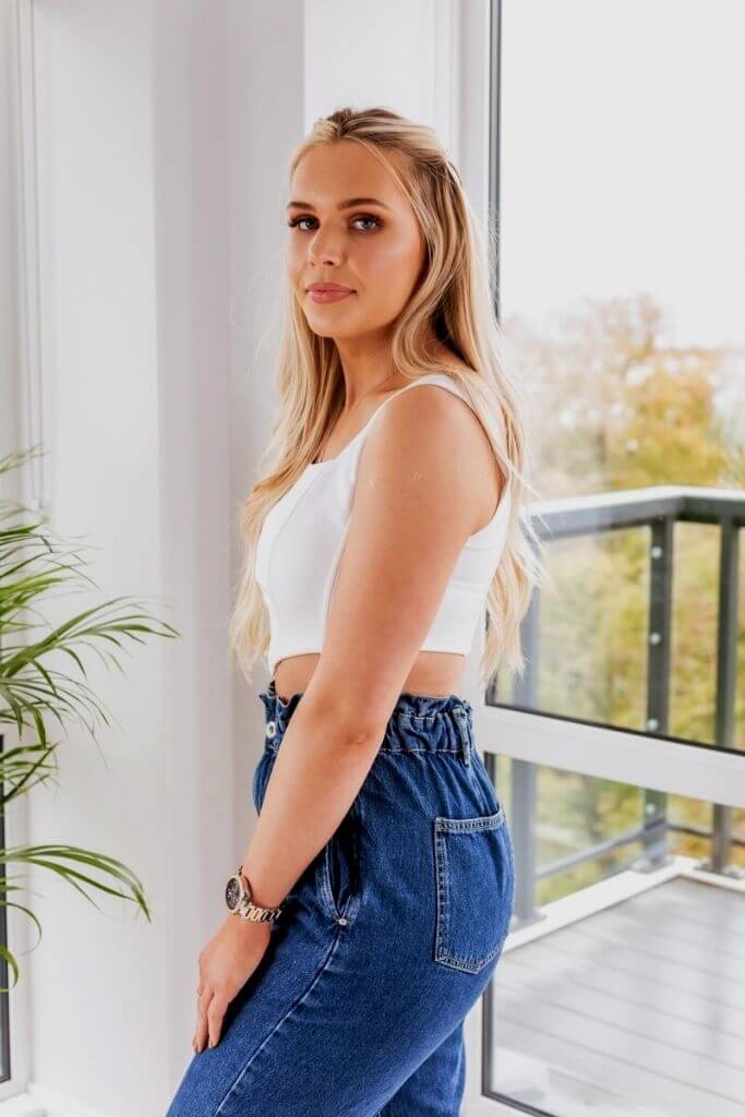 Model creating a bold outfit by matching the elegant White Corset Top with black faux leather cargo pants.