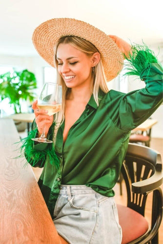 Model wearing the Faux Feather Trim Green Blouse in a casual setting, paired with jeans and flats. This blouse is perfect for everyday wear and adds a touch of fun and flirty style to any outfit.